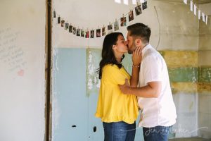 couple kissing under hung photos after their surprise proposal in indiana pa