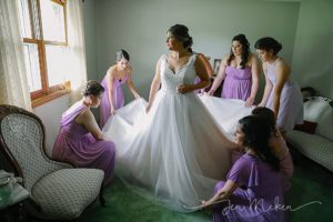 bridesmaids helping with the wedding dress