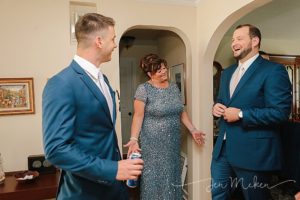 mom of the groom laughing with her sons