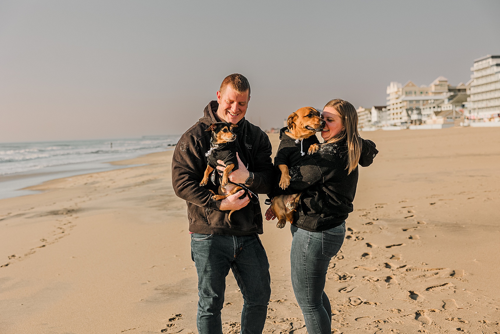 Lifestyle dog session Ocean City Maryland dogs playing near ocean waves with relaxed natural movement