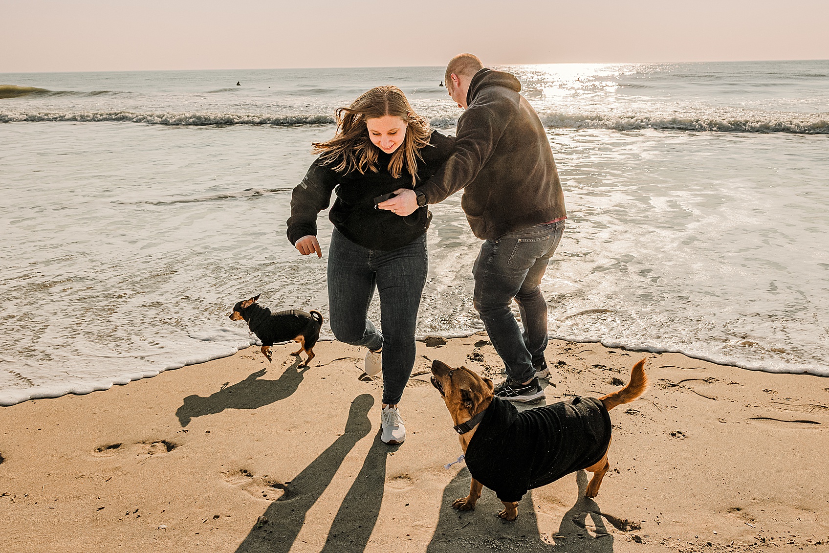 Candid dog photography Ocean City MD two dogs running on empty beach joyful and energetic moment