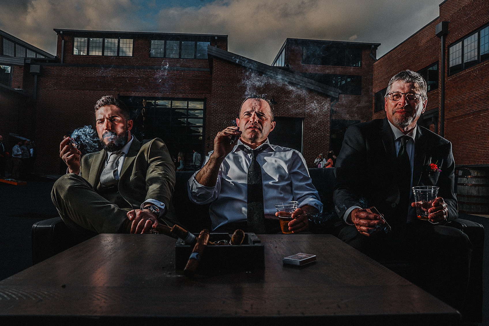 Groomsman smoking cigar in dramatic light